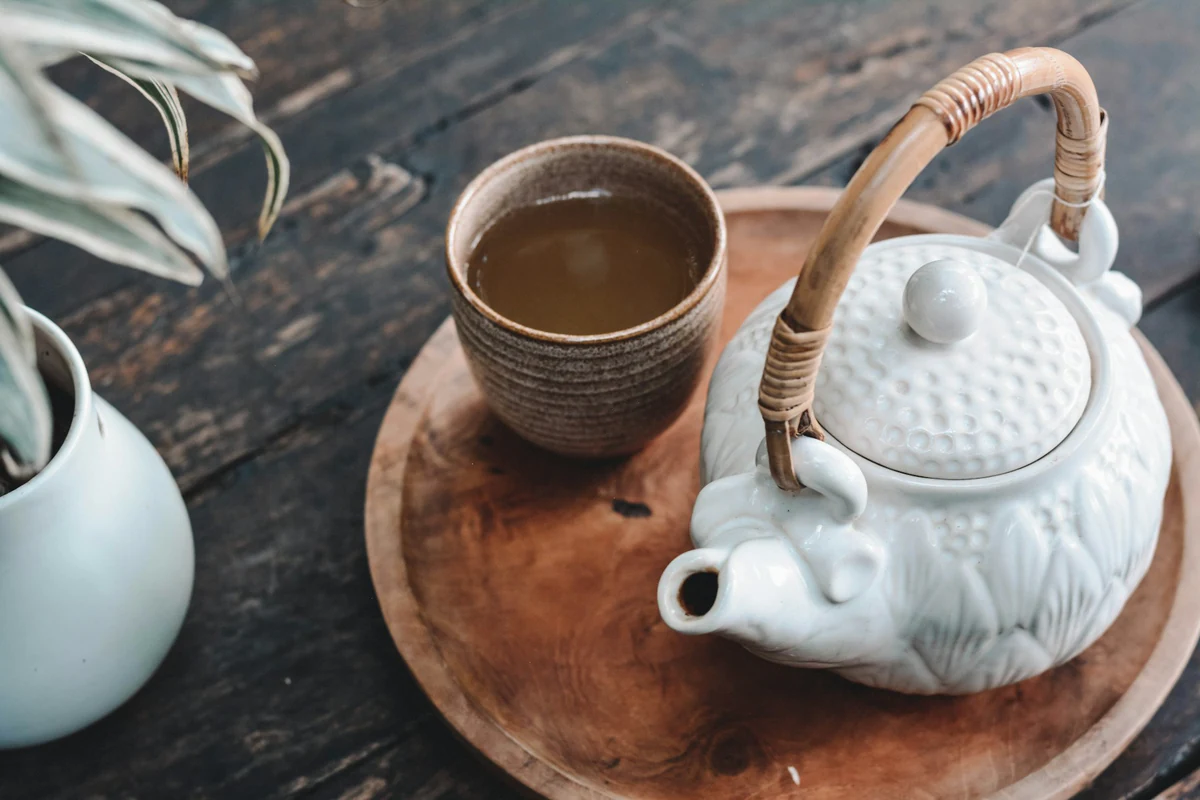 木桌上的暖色茶壶与茶杯